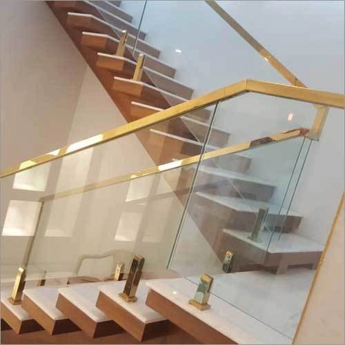 Modern glass staircase with gold trim railing