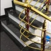 Gold metal staircase railing with wooden posts