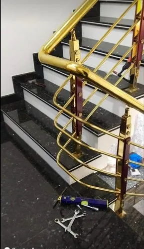 Gold metal staircase railing with wooden posts