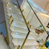 Modern glass staircase with gold metal railing