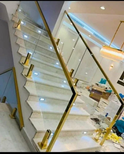 Modern glass staircase with gold metal railing